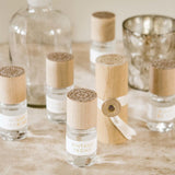 Skeem Print Block Perfumes with carved wooden cases grouped on a table with glass bottles