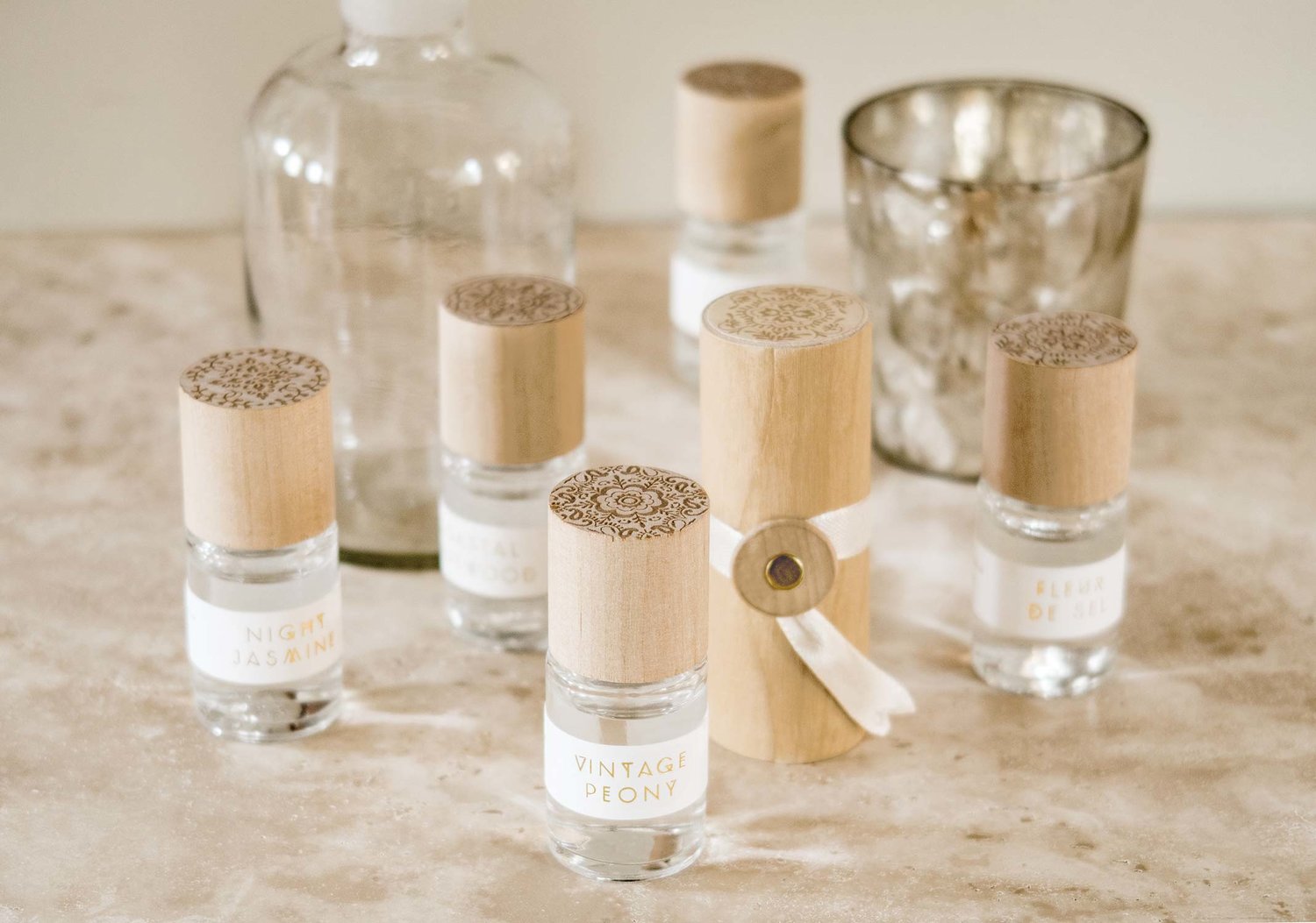 Skeem Print Block Perfumes with carved wooden cases grouped on a table with glass bottles