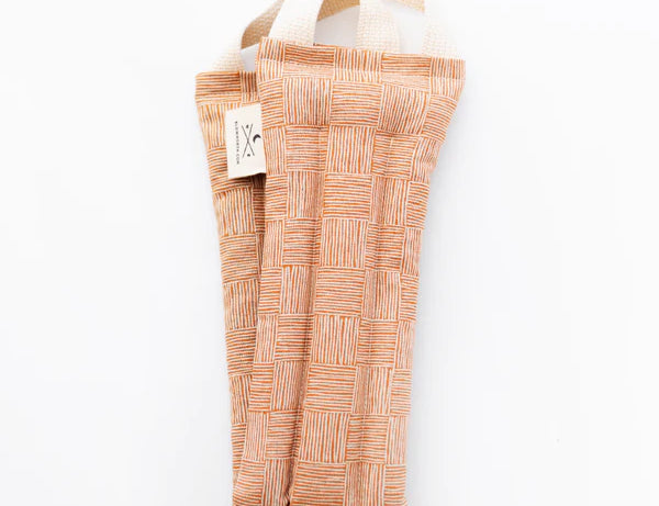Slow North Hot + Cold Neck Wrap in Copper Fields, a terracotta crosshatch print wrap, laid flat