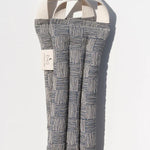 Slow North Hot + Cold Neck Wrap in Haystack, a navy and cream crosshatch print wrap, laid flat