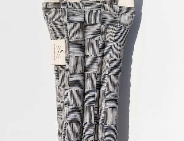 Slow North Hot + Cold Neck Wrap in Haystack, a navy and cream crosshatch print wrap, laid flat
