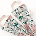 Slow North Hot + Cold Neck Wrap in Hidden Falls, a cream wrap with pink and green florals, laid flat