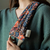 Woman in a green sweater wearing the Slow North Hot + Cold Neck Wrap in Pom Blossom over her shoulder