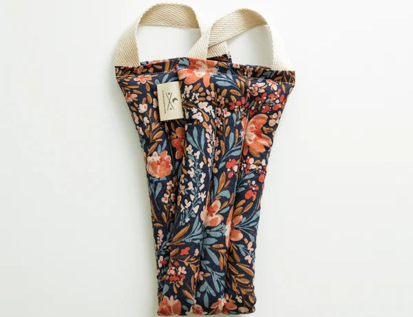 Slow North Hot + Cold Neck Wrap in Pom Blossom, a navy wrap with orange and blue florals, laid flat