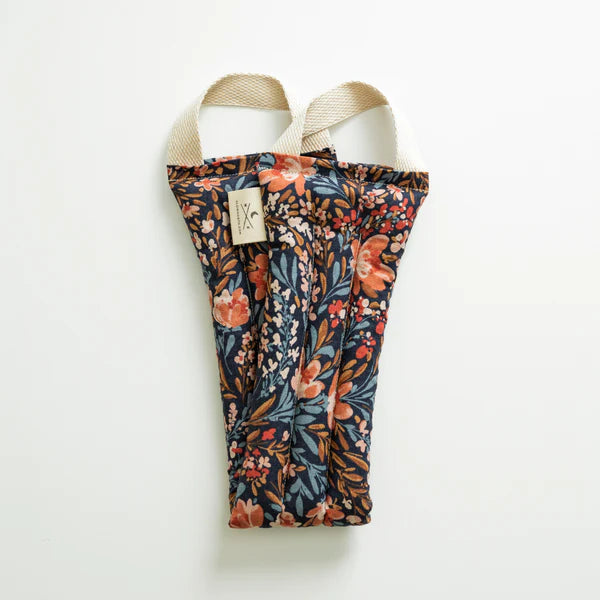 Slow North Hot + Cold Neck Wrap in Pom Blossom, a navy wrap with orange and blue florals, laid flat