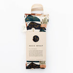 Slow North Hot + Cold Neck Wrap in Rainbow Hill, an abstract navy and rust landscape print with a kraft sleeve