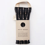 Slow North Hot + Cold Neck Wrap in Solstice, a black wrap with cream moon phases and a kraft sleeve
