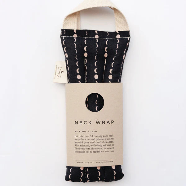 Slow North Hot + Cold Neck Wrap in Solstice, a black wrap with cream moon phases and a kraft sleeve