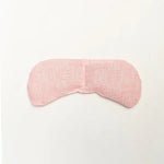 Slow North Migraine Mask in Pink Pampas, a soft pink textured eye mask, laid flat