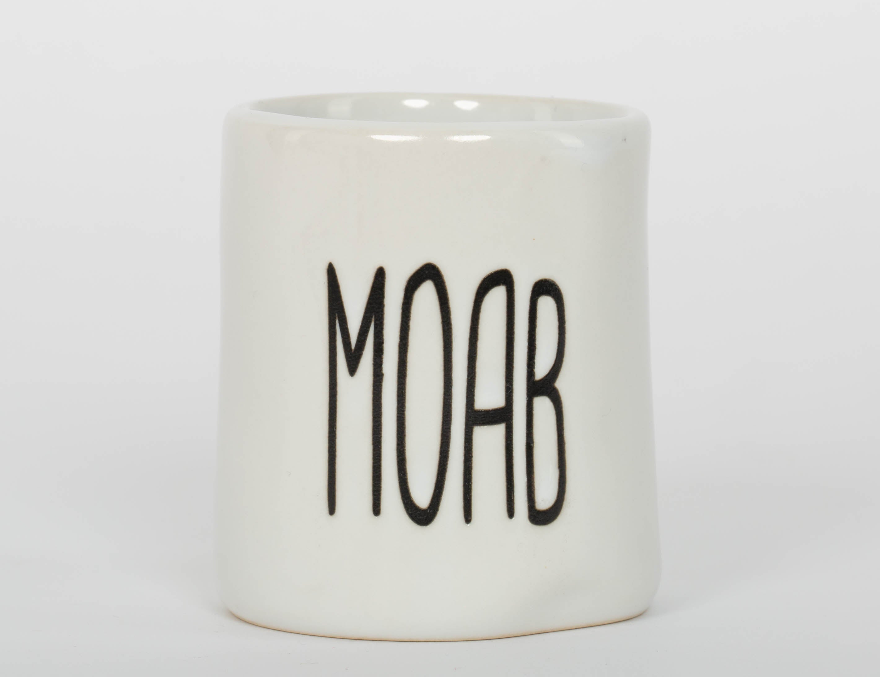 White ceramic Moab shot glass with tall minimal lettering