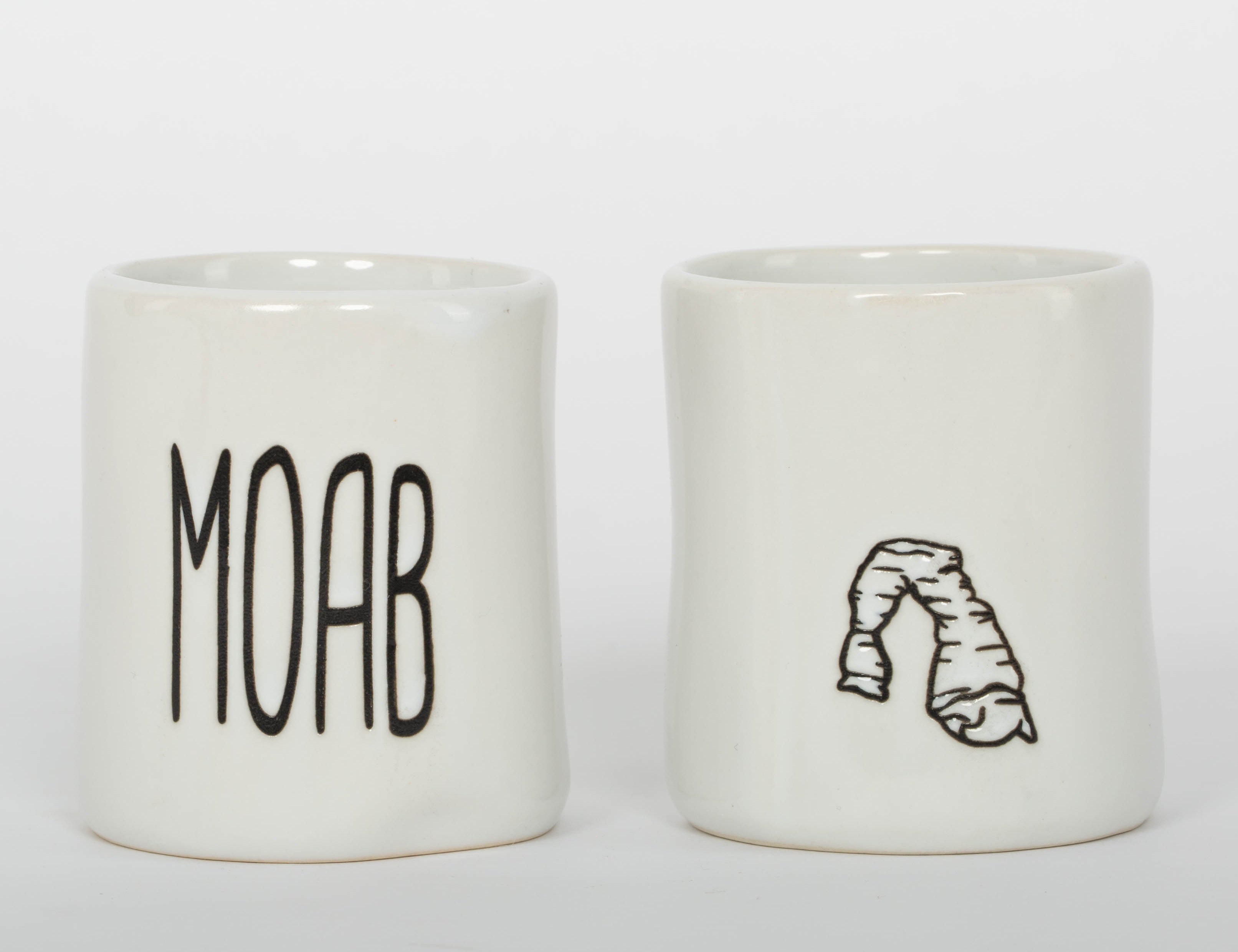 White ceramic Moab shot glass with tall minimal lettering, second view
