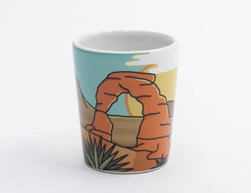 Illustrated Moab shot glass with Delicate Arch against a warm desert sky, second view