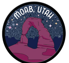 Round glitter Moab magnet with Delicate Arch in rose on a navy sky, lettered Moab Utah