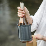 Hand holding a bottle of rose wrapped in the SoYoung Grey Wraparound Ice Pack