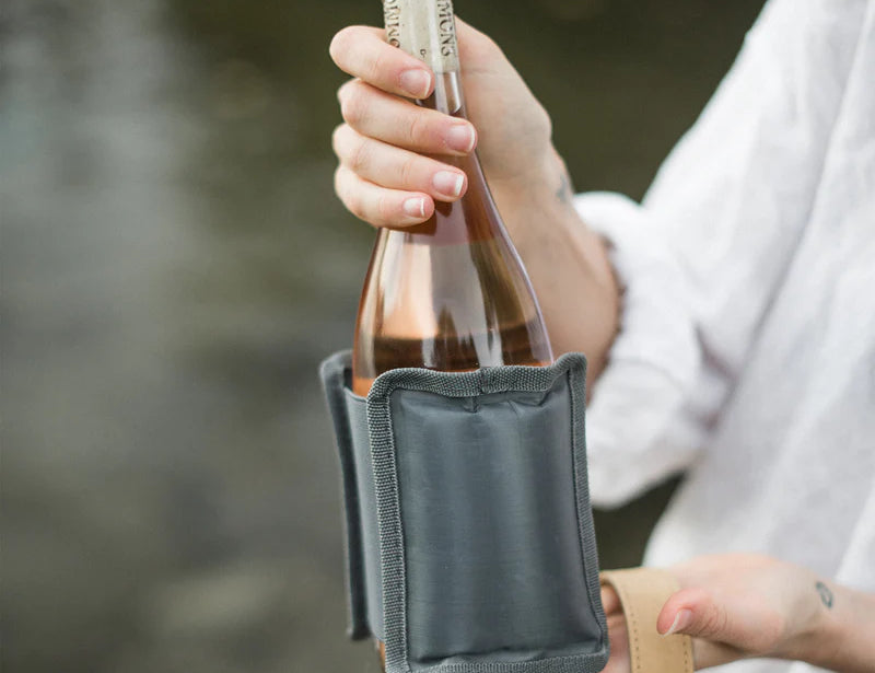 Hand holding a bottle of rose wrapped in the SoYoung Grey Wraparound Ice Pack