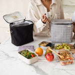 SoYoung Lunch Poche in black open on a marble table with packed lunch containers and fruit