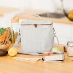 SoYoung Lunch Poche in Pinstripe Heather Grey on a kitchen counter with fruit and a water bottle