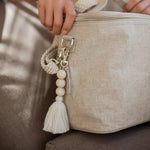 SoYoung Single Beaded Tassel in Cream clipped to a linen lunch bag