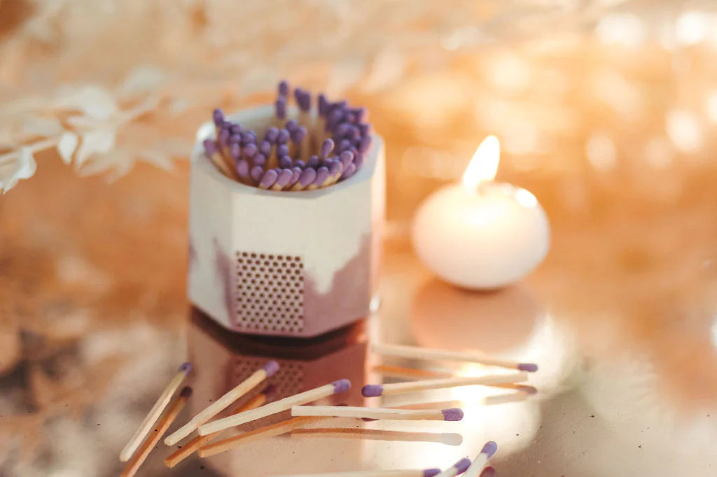 Tenn Prairie Concrete Match Holder in acai and white with purple matches scattered beside a tealight