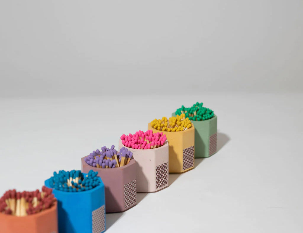 Row of Tenn Prairie Concrete Match Holders in assorted colors filled with colorful matches