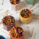 Tenn Prairie Concrete Match Holders in terracotta, peach, mustard and navy filled with rainbow matches