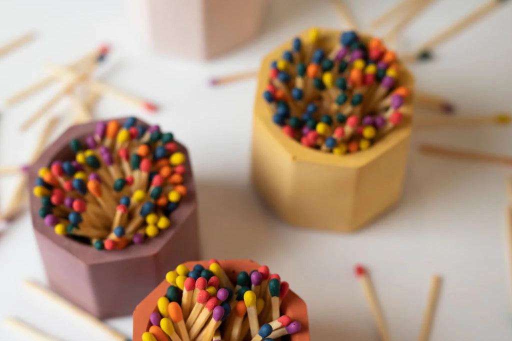 Tenn Prairie Concrete Match Holders in terracotta, peach, mustard and navy filled with rainbow matches