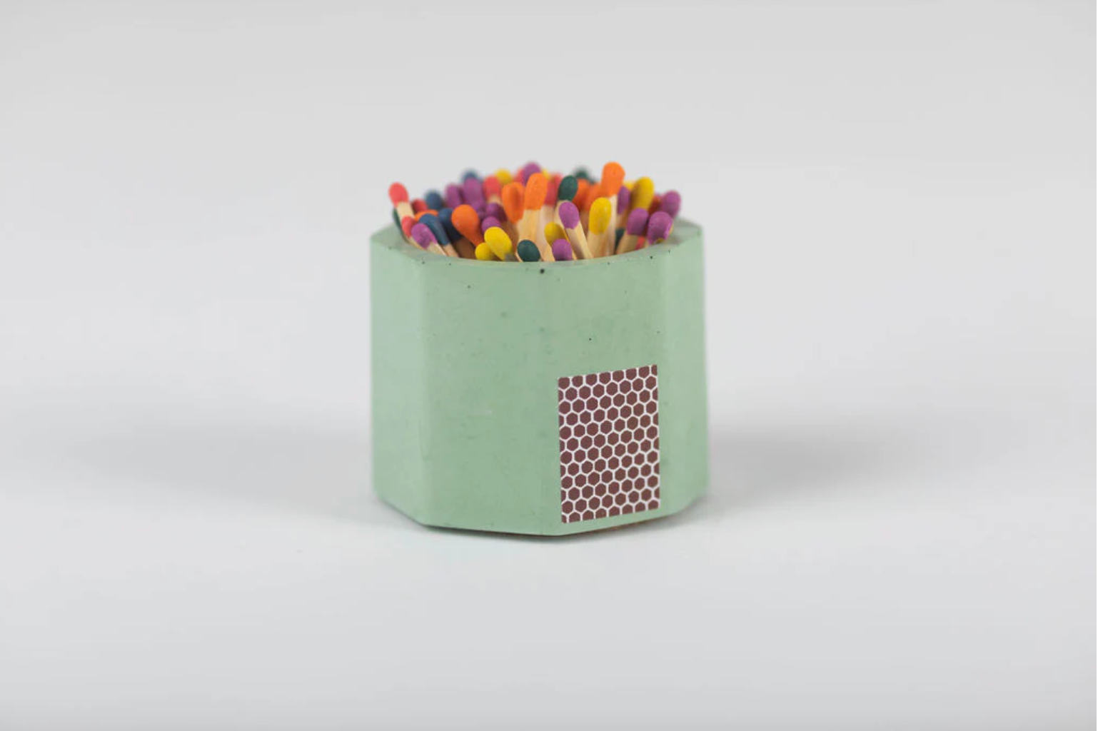 Tenn Prairie Concrete Match Holder in Matcha green with rainbow-tipped matches and a side striker
