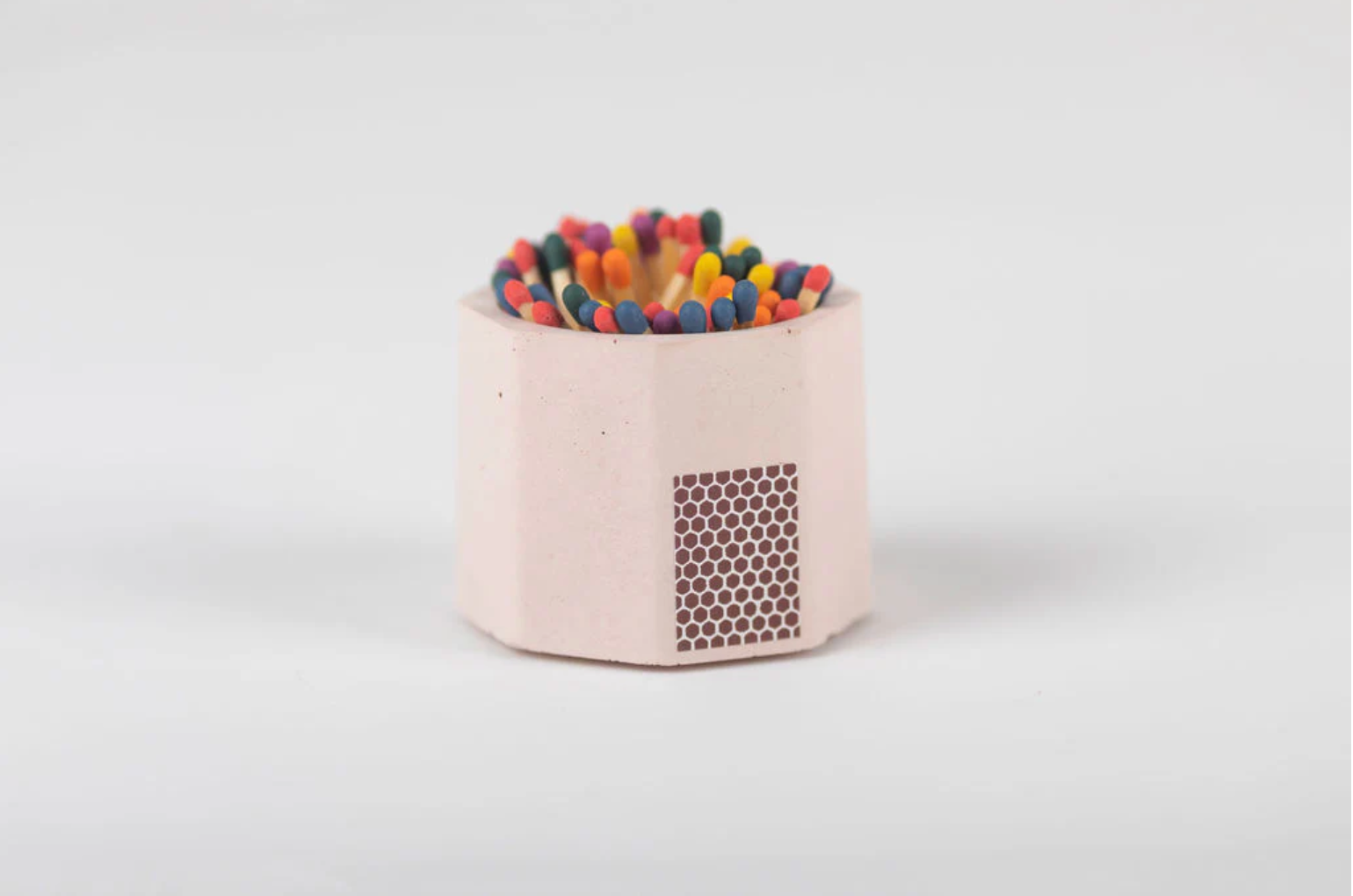 Tenn Prairie Concrete Match Holder in Pink with rainbow-tipped matches and a side striker