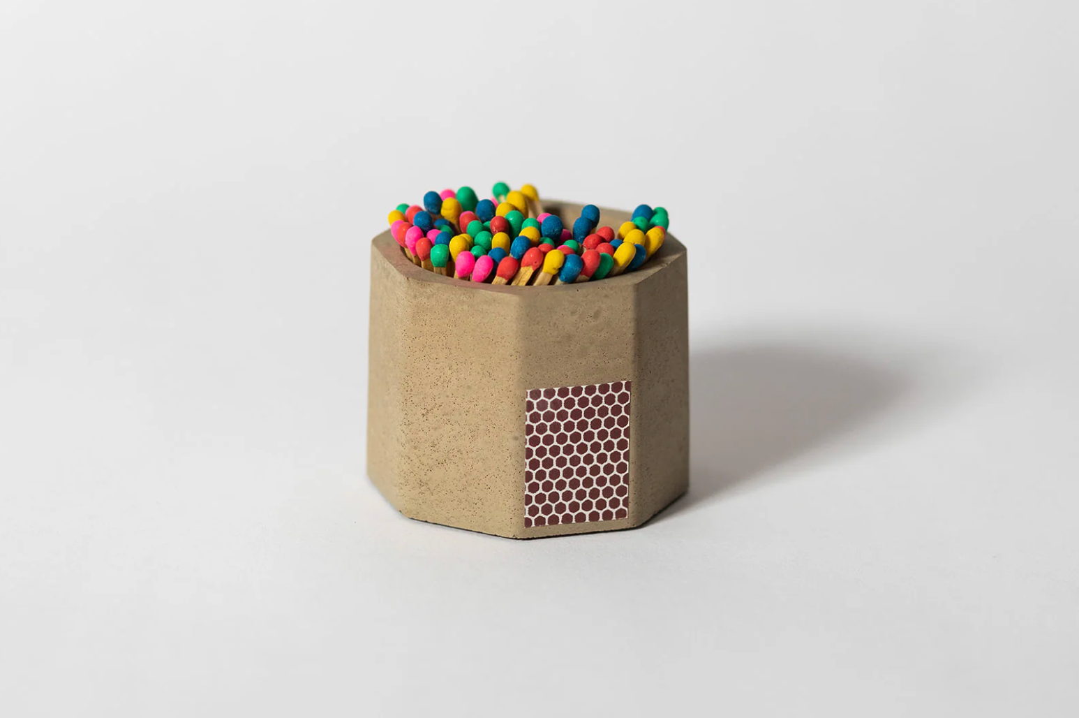 Tenn Prairie Concrete Match Holder in Taupe with rainbow-tipped matches and a side striker