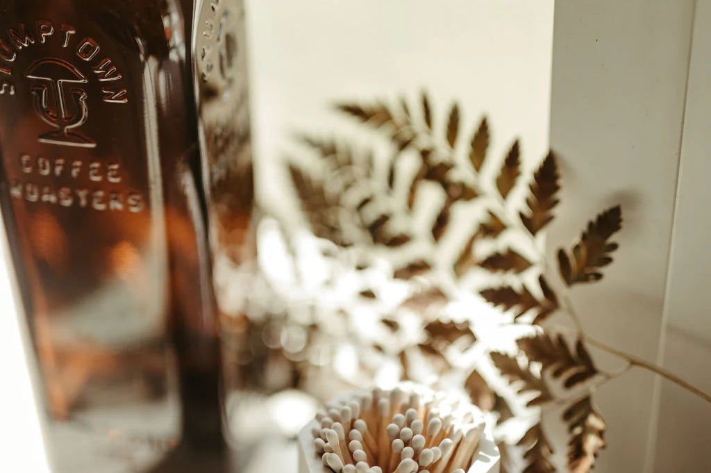 Tenn Prairie Concrete Match Holder in white on a windowsill with a fern and a glass bottle