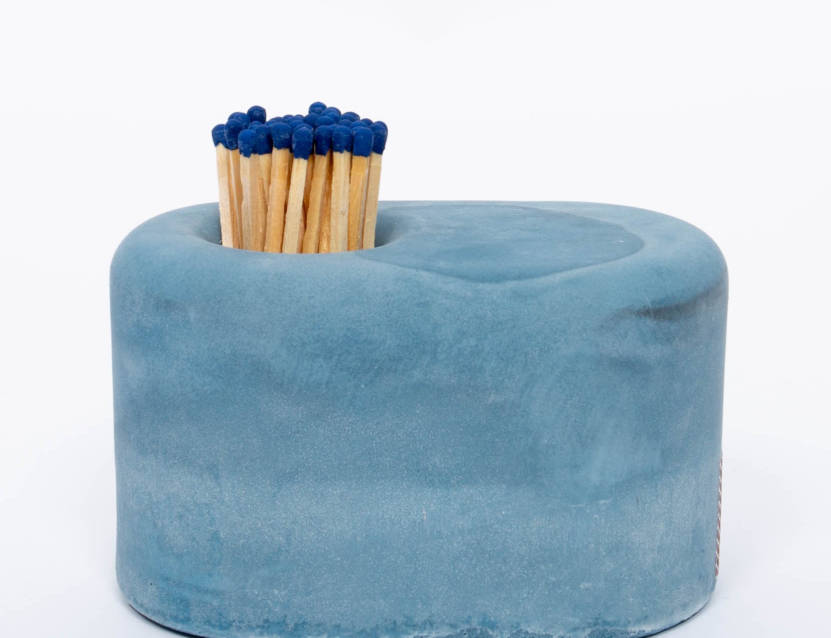 Tenn Prairie Streamliner Match Holder in Blue, a rounded blue concrete holder with blue-tipped matches