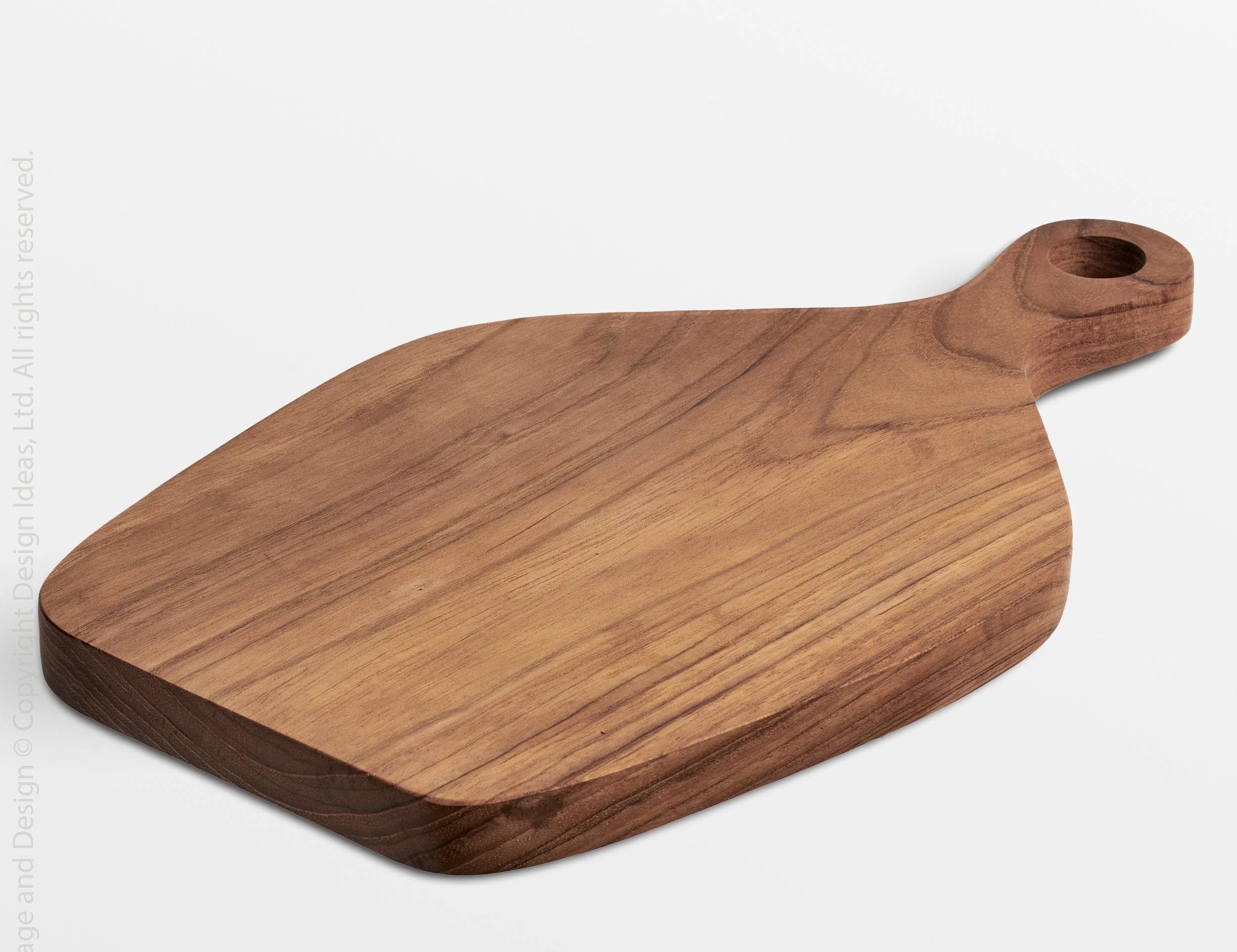 Texxture Chiku Teak Cutting Board, a warm brown paddle-shaped board with a handle hole