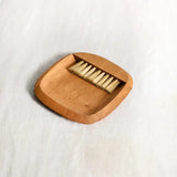 The Collective Belfort Crumb Brush Set from above with the wooden brush resting in its tray