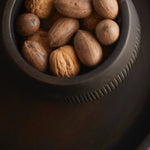 The Collective Chiseled Leila Bowl in black filled with whole walnuts, seen from above