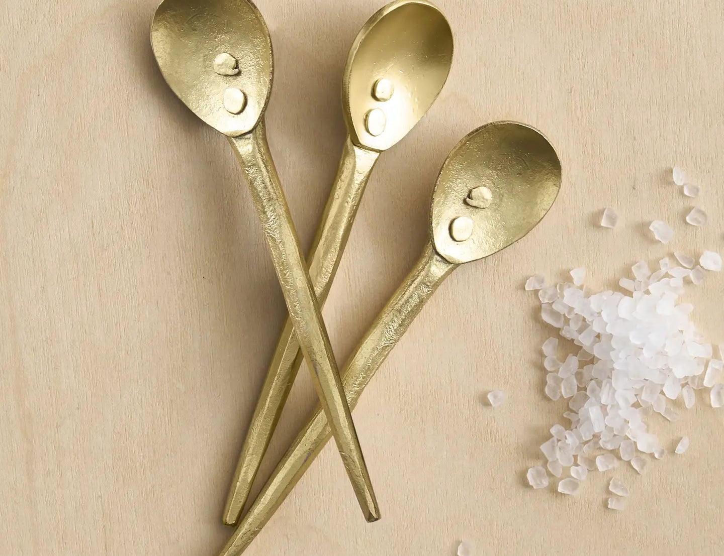 The Collective Forge Mini Spoons in Brass, three hammered gold-tone spoons with coarse salt