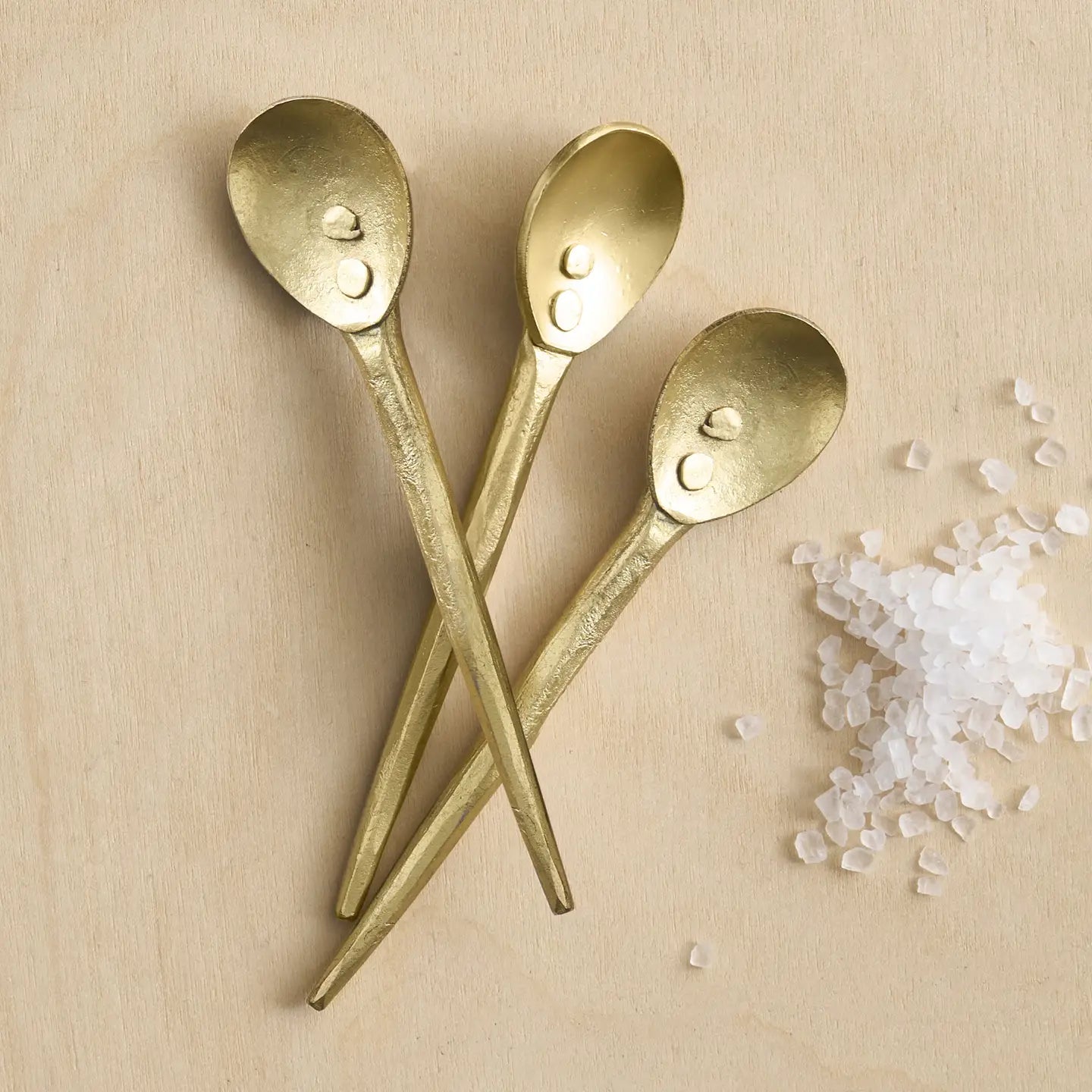The Collective Forge Mini Spoons in Brass, three hammered gold-tone spoons with coarse salt