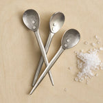 The Collective Forge Mini Spoons in Pewter, three hammered silver-tone spoons with coarse salt