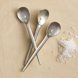 The Collective Forge Mini Spoons in Pewter, three hammered silver-tone spoons with coarse salt