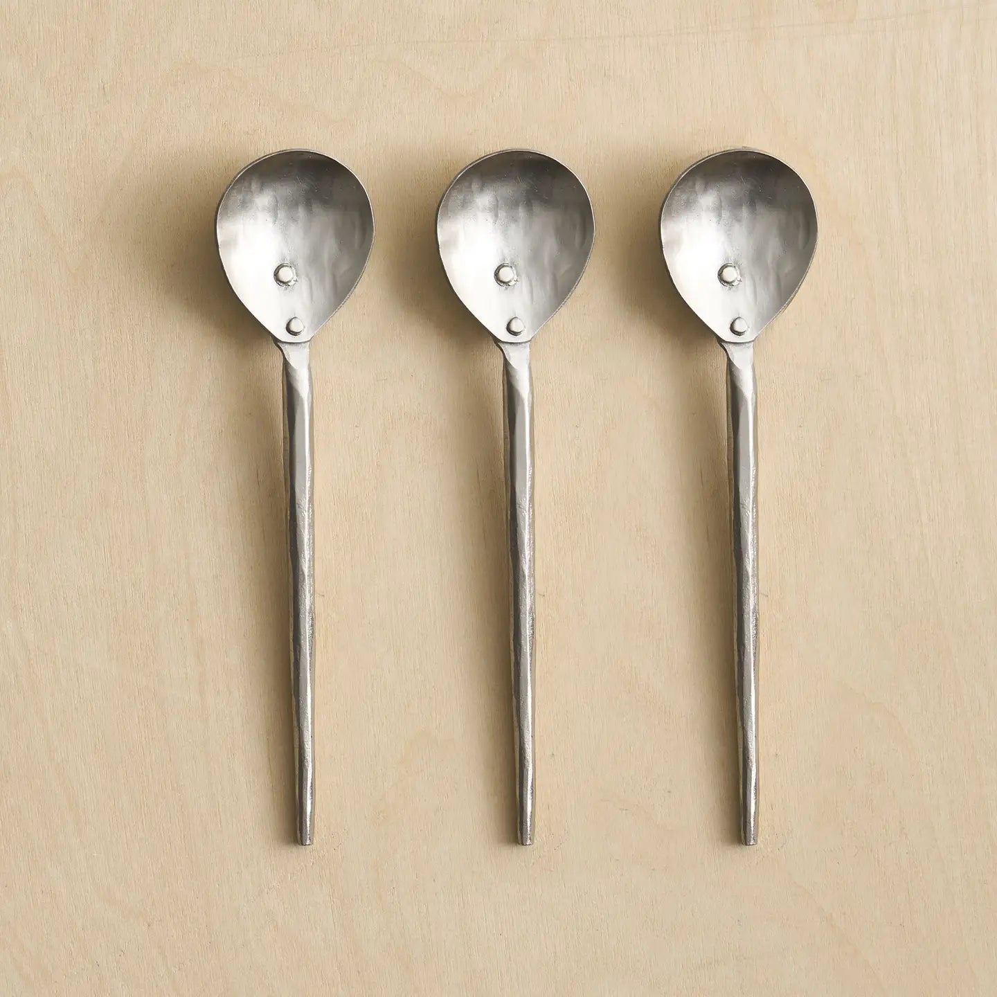 The Collective Forge Pewter Small Spoons Set of 3, hammered silver spoons in a row