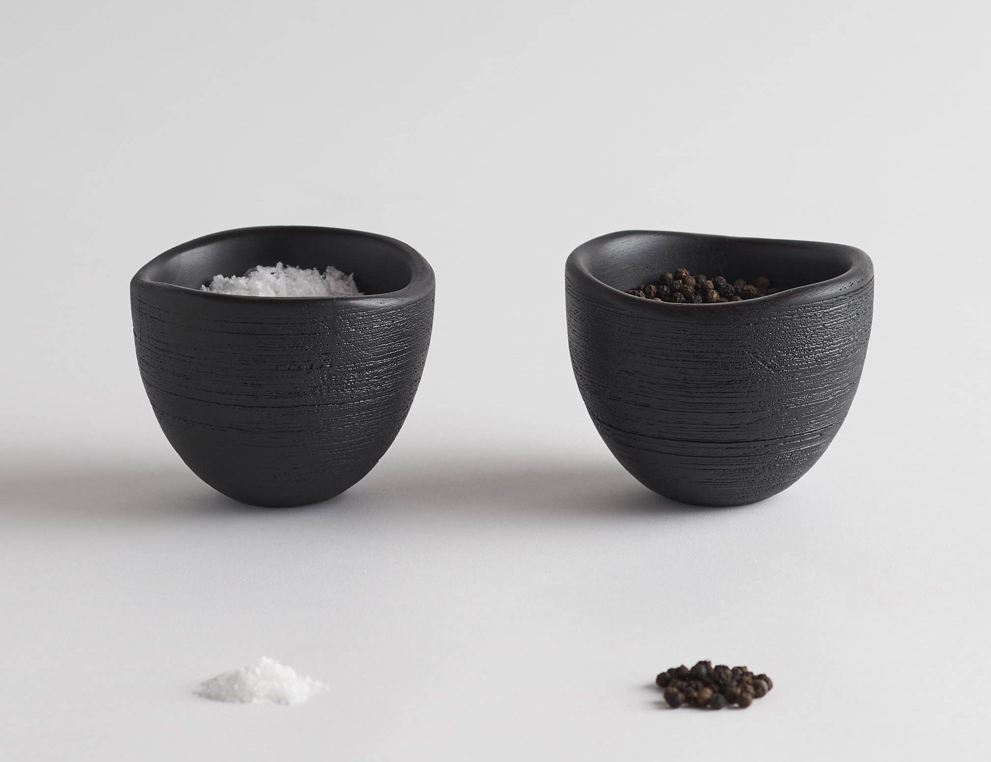 The Collective Groove Tidbit Bowls Set of 2, two small matte black textured bowls with salt and pepper