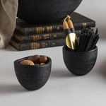 The Collective Groove Tidbit Bowls in black on a desk with pencils and stacked books