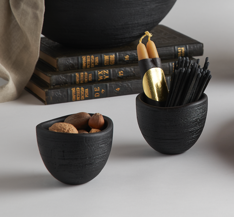 The Collective Groove Tidbit Bowls in black on a desk with pencils and stacked books