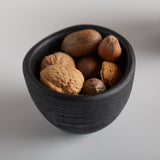 The Collective Groove Tidbit Bowl in black filled with whole walnuts, close-up