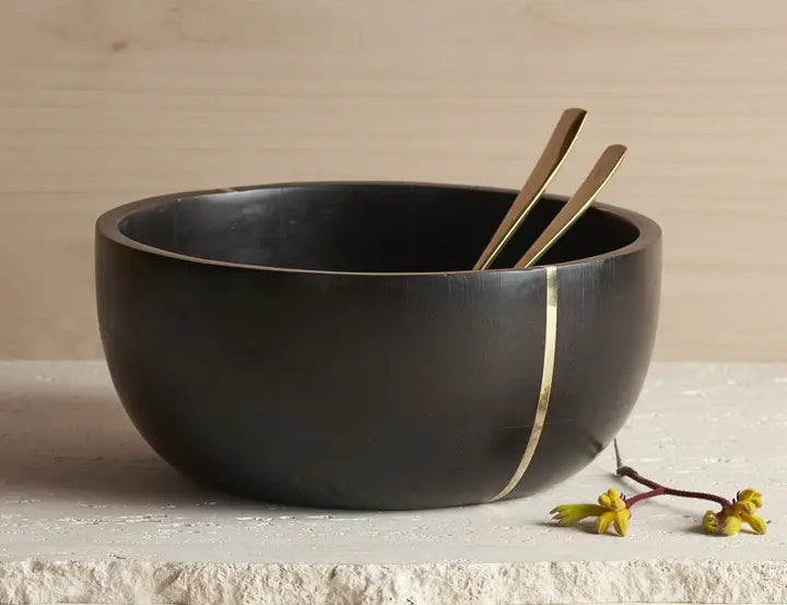 The Collective Mondrian Serving Bowl, a black wooden bowl with a brass inlay stripe and gold servers
