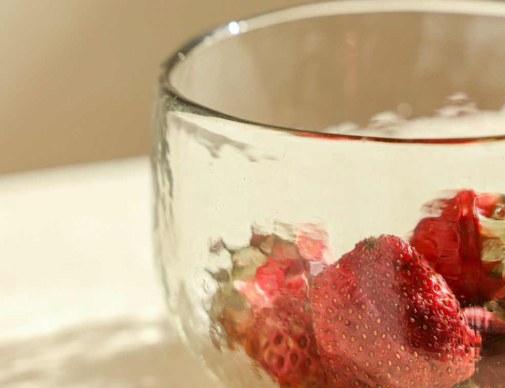 Close-up of The Collective Pebbled Bowl in textured glass holding fresh strawberries