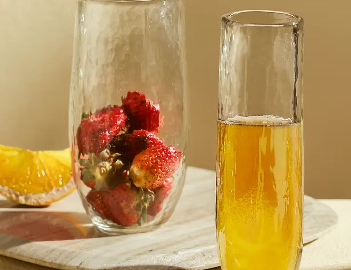The Collective Pebbled Large Glasses holding strawberries and orange juice on a wooden board