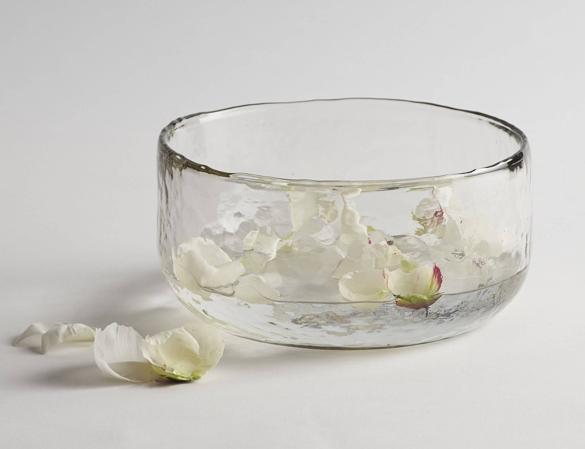 The Collective Pebbled Salad Bowl, a wide textured glass bowl with white flower petals