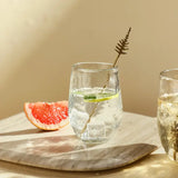 The Collective Pebbled Small Glasses with a sparkling drink and grapefruit on a wooden board