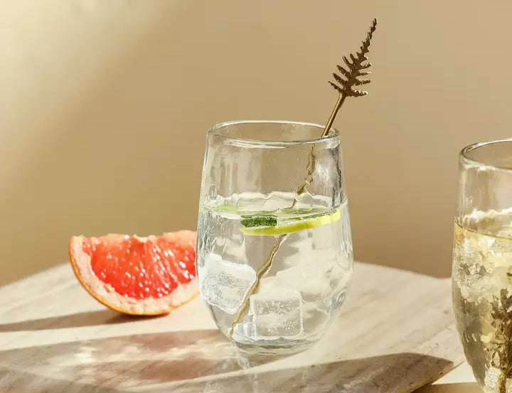 The Collective Pebbled Small Glasses with a sparkling drink and grapefruit on a wooden board