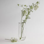 The Collective Pebbled Tall Vase, a slim textured glass vase holding wildflower stems